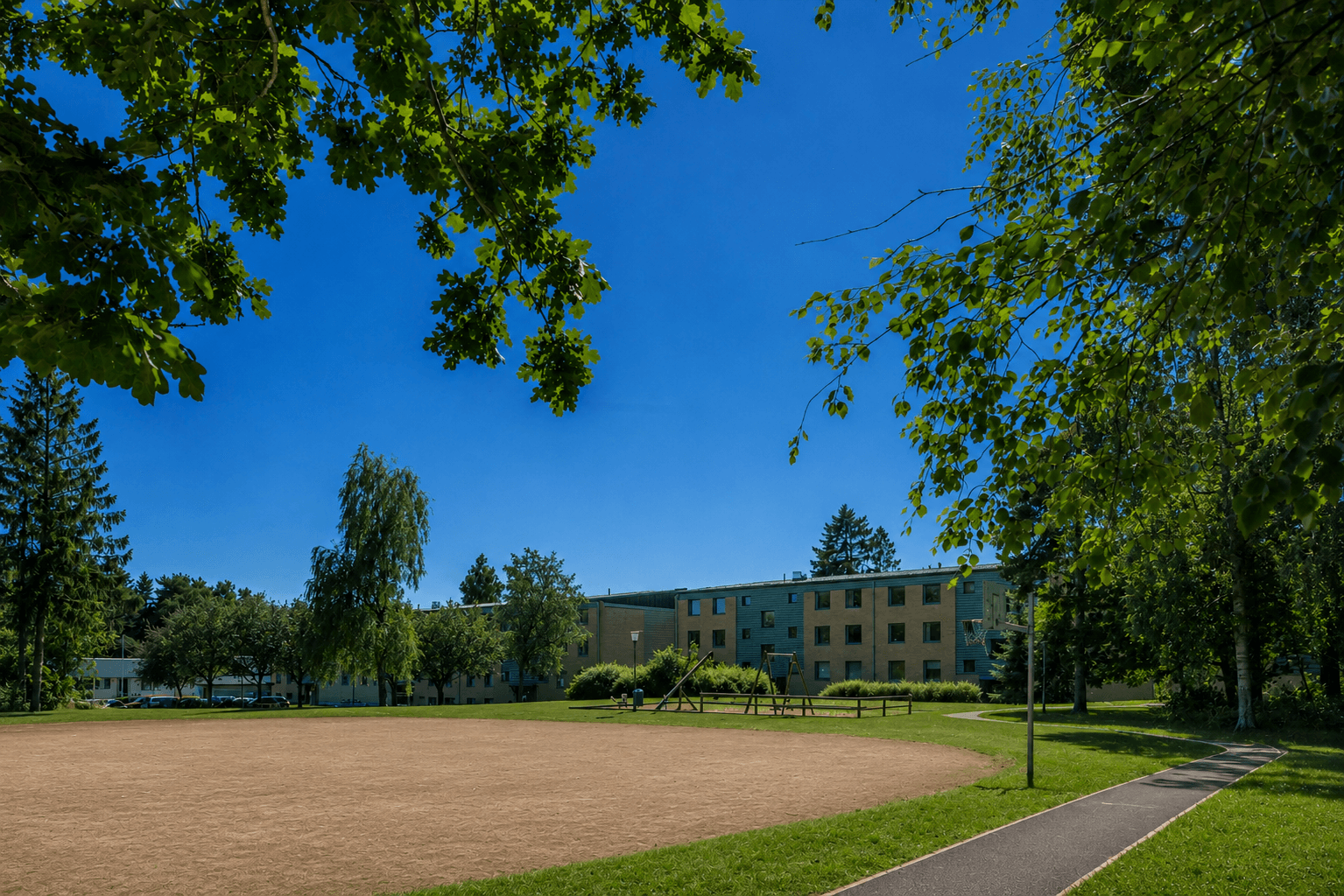 Renderad sommar fotbollsplan och lekplats mot husen, juni 2026.png