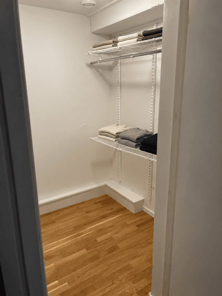 Minimalist garderob med trådhyllor.png