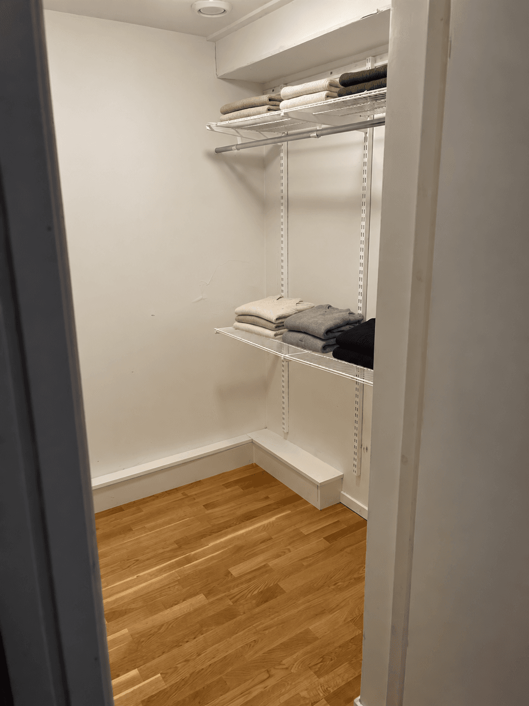 Minimalist garderob med trådhyllor.png